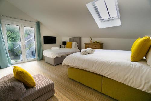 莱姆里吉斯Largigi, Free Parking, Close to the Beach and Town Centre Rooms的一间卧室配有两张带黄色枕头的床和窗户。