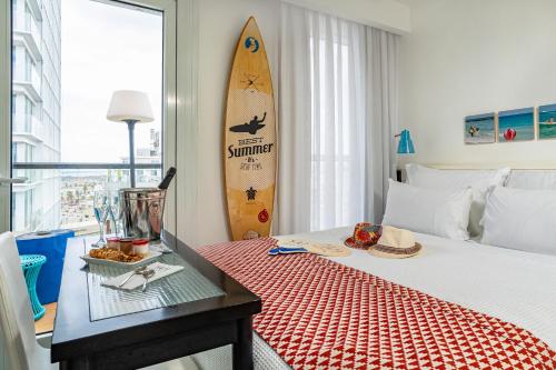 特拉维夫延慕精品特拉斯酒店的卧室配有一张床,墙上设有冲浪板