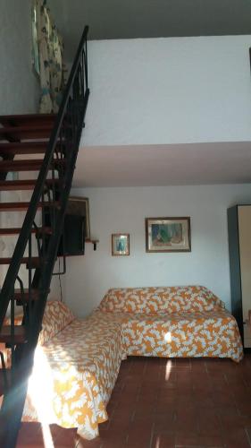 卡洛福泰Country House La Caletta Carloforte的一间卧室设有一张床和一个楼梯