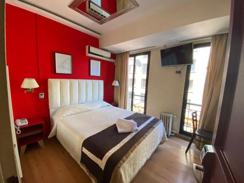 圣地亚哥Intimo Hotel Miraflores的一间带红色墙壁、一张床和电视的卧室