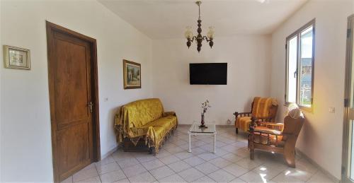 西尼斯科拉Cosy home with private parking near by sea的客厅配有沙发、椅子和电视