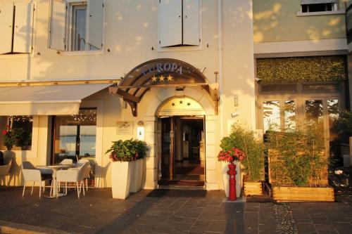 代森扎诺-德尔加达欧洲酒店的大楼前设有桌椅的餐厅