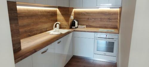 希萨里亚Релакс Хисаря的厨房配有白色橱柜和木制台面