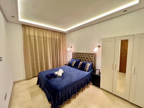 卡萨布兰卡luxury studio-Haut standing MAARIF的一间卧室配有一张带蓝色棉被的床