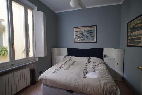 帕尔马Appartamento moderno a 2 passi dal Duomo di Parma的一间设有床铺的卧室,位于一间拥有蓝色墙壁的房间