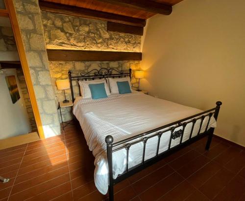 莫什劳斯Petra Nova Villas的一间卧室配有一张带蓝色枕头的大床