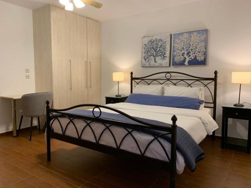 莫什劳斯Petra Nova Villas的一间卧室配有一张床、一张桌子和两盏灯。