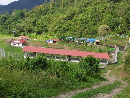 GorkhāGorkha Organic Agro Farm的山上有红色屋顶的建筑
