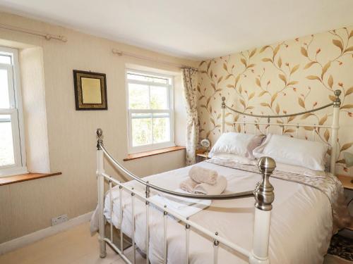 帕The Ark Cottage的卧室配有白色的床和2扇窗户。