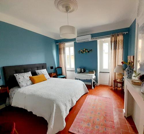 BadensVilla Saint Léon的一间卧室设有蓝色的墙壁和一张黄色枕头的床