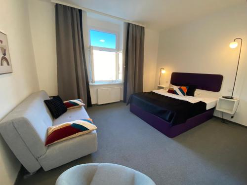萨格勒布Apartments DOLAC 1 Zagreb的客厅配有沙发、一张床和椅子