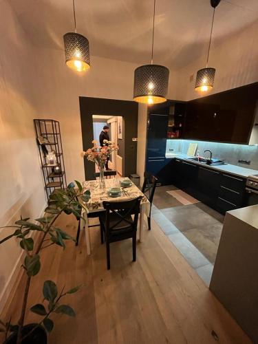 琴斯托霍瓦Przytulny Apartament w Centrum的厨房以及带鲜花桌的用餐室。