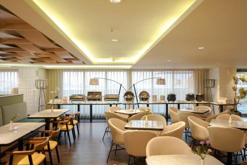三宝垄Louis Kienne Hotel Pemuda的一间带桌椅的餐厅和一间酒吧