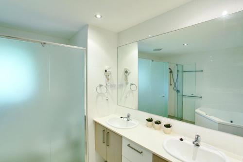 彩虹海滩6 Orania Court Rainbow Shores的浴室设有2个盥洗盆、淋浴和镜子。