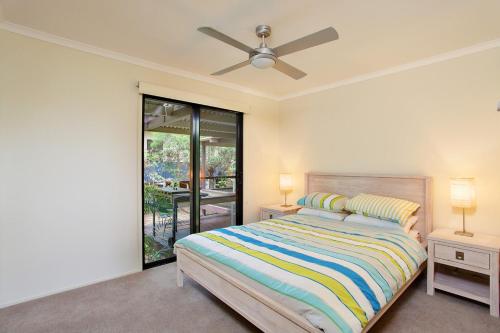 彩虹海滩6 Orania Court Rainbow Shores的一间卧室配有一张床和吊扇