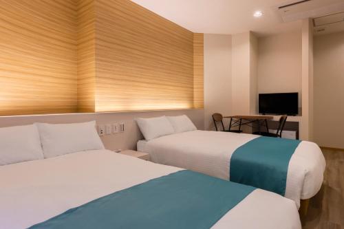冲绳岛市HOTEL Gran Arenaホテルグランアリーナ的一间酒店客房,设有两张床和电视
