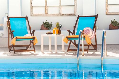 根纳迪Villa Dionysus的游泳池畔的两把椅子和一张桌子