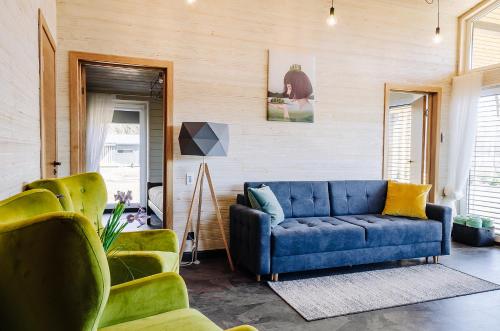 阿卢克斯内Holiday Houses LILLE`S with sauna的客厅配有蓝色的沙发和两把椅子