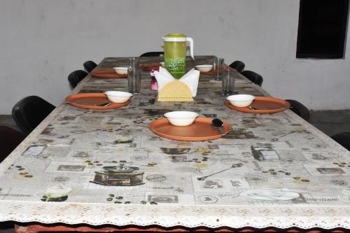 JhirnaCorbett Bhavesh home Stay的桌子上带圆桌布的桌子,上面有碗和盘子