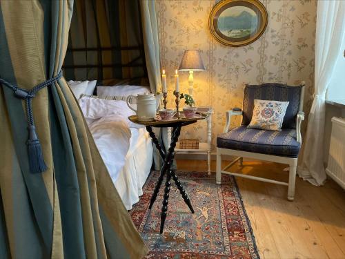 Floda纳斯劳特乡村民宿的卧室配有1张床、1张桌子和1把椅子