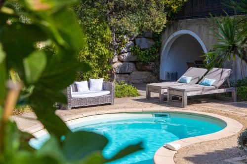 圣特罗佩拉巴斯蒂德安托万酒店的庭院内的游泳池,配有两把椅子和一张桌子