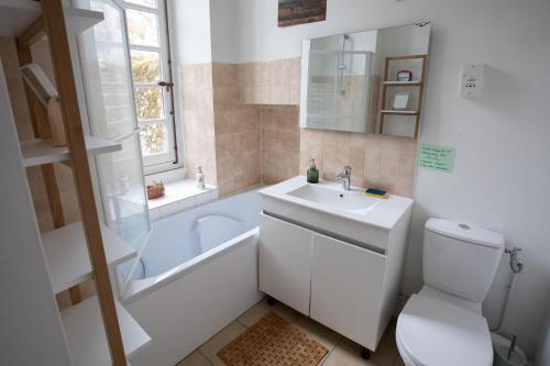 勒芒Demeure Jousset des Berries的一间带水槽、浴缸和卫生间的浴室