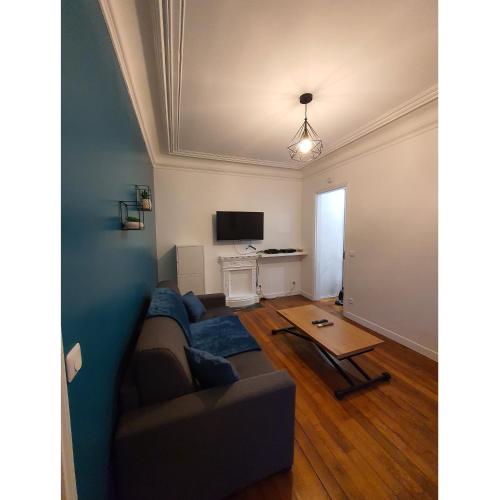 圣芒代Un appartement authentique à deux pas de Paris .的带沙发和电视的客厅