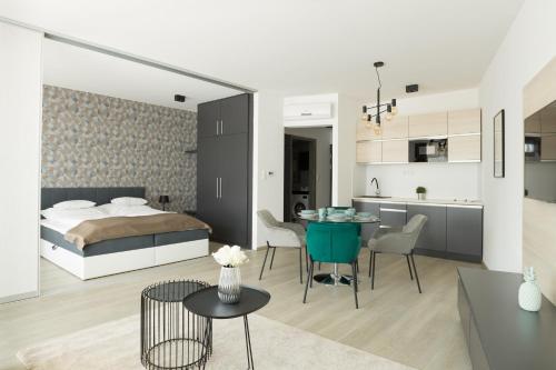 德布勒森Parizs Garden Apartments的一间卧室和一间带一张床铺和一张桌子的客厅