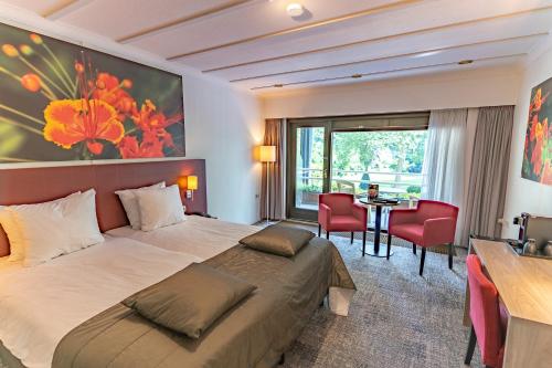 洛赫姆Hotel Hof van Gelre by Flow的酒店客房带一张床、一张桌子和椅子