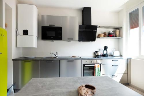 安锡55 m²/ Chez LÔrette/ 250m LAKE/ PRIVATE PARKING的厨房配有不锈钢用具和桌子