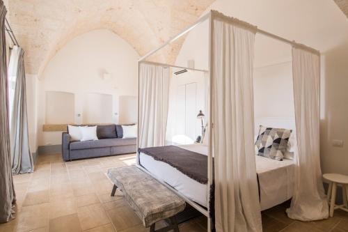 法萨诺Masseria San Giovanni - Epoca Collection的一间卧室配有一张床和一张沙发