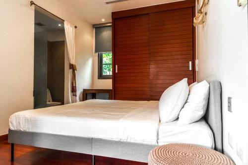 普吉镇The residence resort Villa 1bdr Private Pool的一间卧室配有一张大床和木制床头板