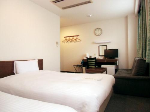 仙台绿线酒店的配有一张床和一张书桌的酒店客房