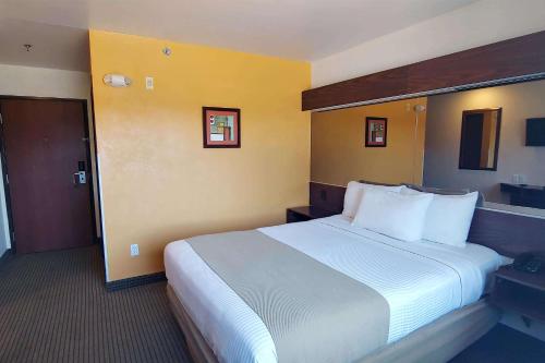 华雷斯城Microtel Inn and Suites by Wyndham Ciudad Juarez, US Consulate的酒店客房配有一张带白色枕头的大床