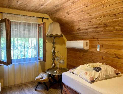 TiszaderzsHarcsáztat-Lak的一间卧室配有一张床、一张桌子和一个窗户。