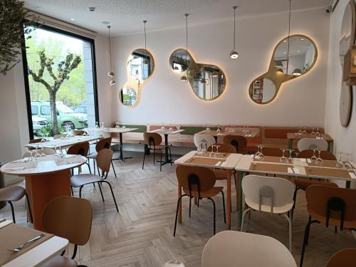 艾因萨Apartahotel Dos Ríos Ainsa的餐厅设有桌椅和镜子
