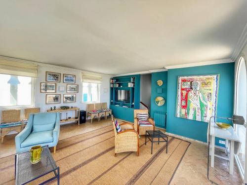 丹吉尔Vue Imprenable Le balcon de tanger的客厅设有蓝色的墙壁和椅子