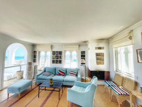 丹吉尔Vue Imprenable Le balcon de tanger的客厅配有蓝色的沙发和椅子