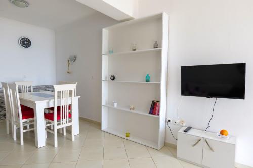 卢科沃Duka's House的白色的客厅配有桌子和电视。