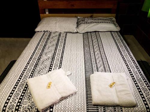 卡利马Hostal Casa del Viento Kitesurf & Adventure的床上有两条白色毛巾