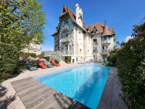多维尔Villa Augeval Hôtel de charme & Spa的建筑前带游泳池的庄园