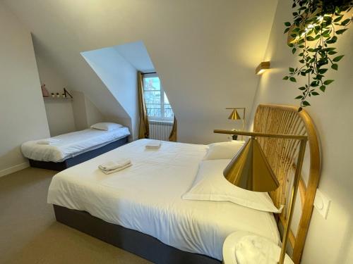 圣艾尼昂Maison des fleurs的一间卧室配有两张带白色床单的床