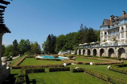 克吕塞耶Château des Avenieres - Relais & Châteaux的一座带花园和游泳池的大型建筑