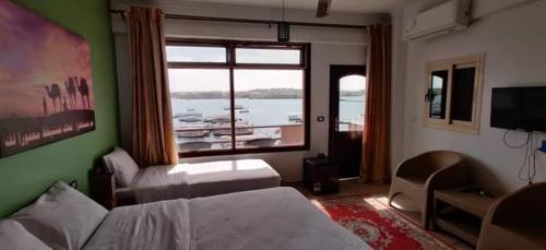 阿斯旺Villa Misk的一间卧室设有一张床和一个享有船只美景的窗户。