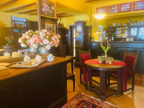 坎普-博尔恩霍芬Hotel Anker的一间餐厅,在房间内摆放着桌椅和鲜花