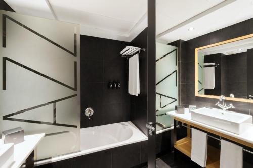 巴塞罗那爵士酒店的带浴缸和盥洗盆的浴室
