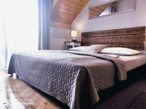 梅希莱尼采Podkowa的一间卧室配有一张大床和木制床头板