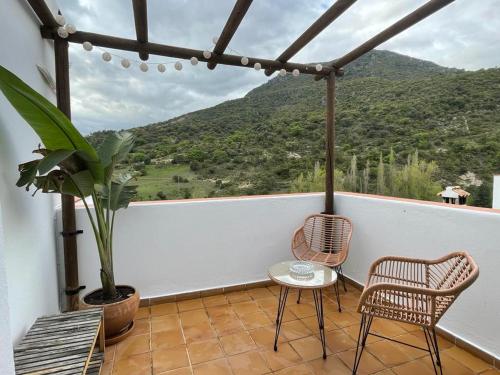 贝纳马奥马Suite Rural Oasis的阳台配有2把椅子和1张桌子,享有风景。