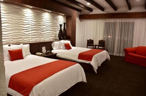 瓜达拉哈拉Radisson Hotel Tapatio Guadalajara的酒店客房带两张床和一张红色沙发