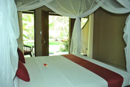 佩母德兰彭多克拉哈余旅馆的卧室配有白色的床和窗户